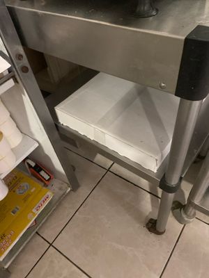 une table en métal sur laquelle est posée une casserole, dans une cuisine