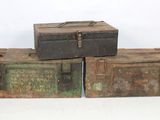 three old metal boxes stacked on top of each other on a white surface