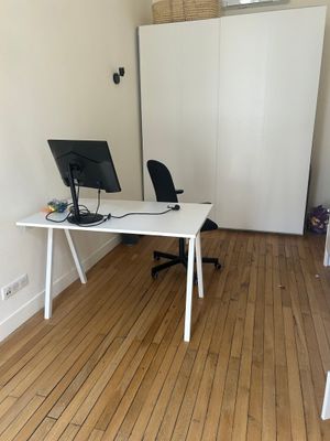 a white desk with a computer on it in the corner of a room