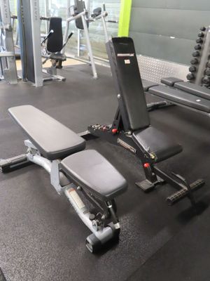 a gym room with a bench, weights, and other equipment