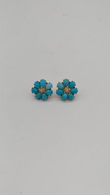 une paire de boucles d'oreilles en turquoise posées sur un fond blanc