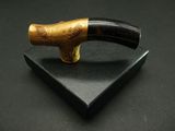 a pipe with a wooden handle on a black surface