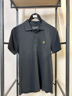 un polo noir suspendu à un cintre dans un magasin de vêtements