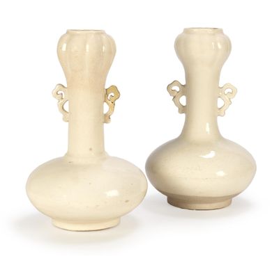 two white vases that are sitting on a table