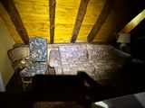 a couch and a chair in the attic of a house