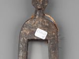 a close up of a wooden figurine with a tag on it