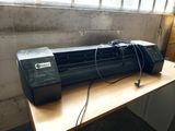 an image of a printer sitting on a desk in front of a window