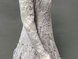 an image of a mannequin wearing a gray dress with feathers on it