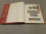 an open book with stamps on it sitting on a table