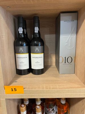 des bouteilles de vin sur une étagère dans un magasin, avec une étiquette de prix