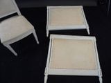 two white chairs and a table with a chair and a chair in the background