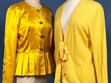 two mannequins dressed in yellow jackets and skirts on a mannequin stand