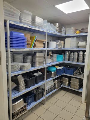 beaucoup d'assiettes et de casseroles sur les étagères de la cuisine