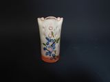 a small vase with a flower design on it
