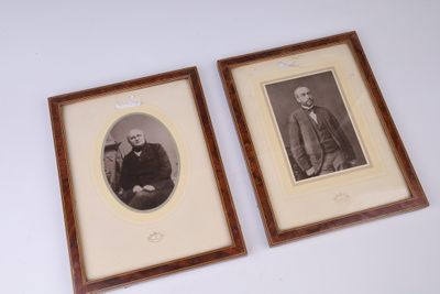 deux photos encadrées représentant deux hommes en costume-cravate assis l'un à côté de l'autre