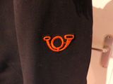a close up of a black jacket with an orange logo on it