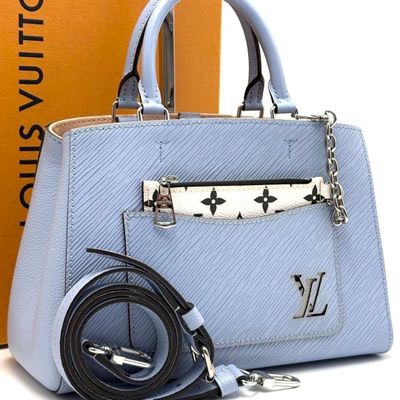 a blue handbag with a belt and a box