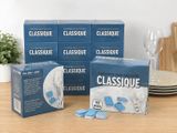 trois boîtes de « Glassique » classique posées sur une table à côté d'un verre de vin