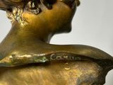 bronze statue of a woman with a hat on her head