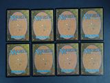six magic the gathering game cards are arranged on a black surface