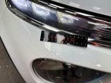 a close up of a car ' s headlight with a sticker on it