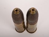 two bullet shells on a white surface with a white background