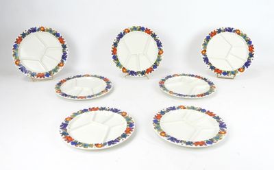 six plates with colorful designs are arranged on a white surface