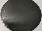 a metal plate with holes on it on a white surface