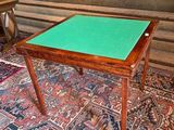 a table with a green top sitting on a rug
