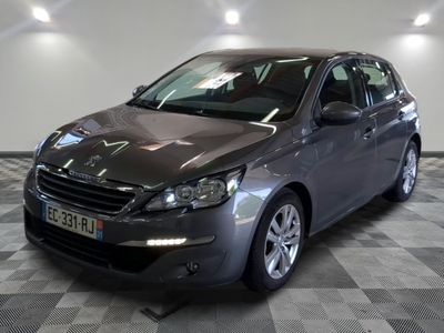 La voiture grise est garée sur le sol à damier du garage.