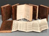 cinq livres ouverts posés les uns à côté des autres sur une table