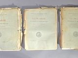 trois vieux livres posés sur une table l'un à côté de l'autre
