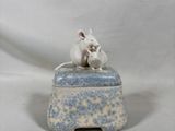 figurine en porcelaine représentant deux souris assises sur une boîte bleue et blanche