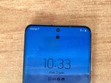 the back of a blue phone with a screen showing the time on it