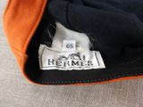 an orange and black jacket with a label on it sitting on a couch