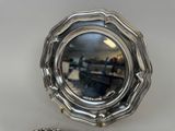 a mirror that is sitting on a table next to a silver object
