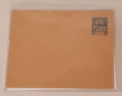 une enveloppe marron sur laquelle est collé un timbre, posée sur une table