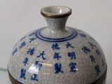 a small blue and white vase sitting on a glass table