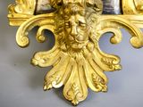 a gold clock with a lion head on it