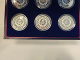 six silver coins in a blue box on a white table