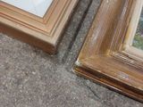 two picture frames sitting on the ground next to each other