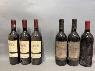 six bottles of wine are lined up on a table