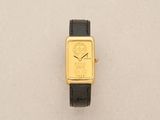 an image of a gold watch with a black strap on a white surface