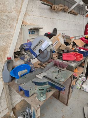 un homme debout devant une table sur laquelle sont posés des outils