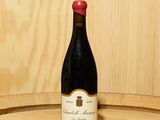 une bouteille de vin posée sur un tonneau