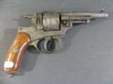 an old revolver with a wooden handle on a gray surface