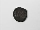 une vieille pièce de monnaie portant une inscription, posée sur une surface blanche