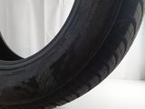 a close up of a tire on a white surface with a white curtain in the background