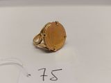 une image d'une bague en or sur une surface blanche avec une étiquette de prix