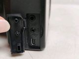 a person holding a camera that has a small button on it